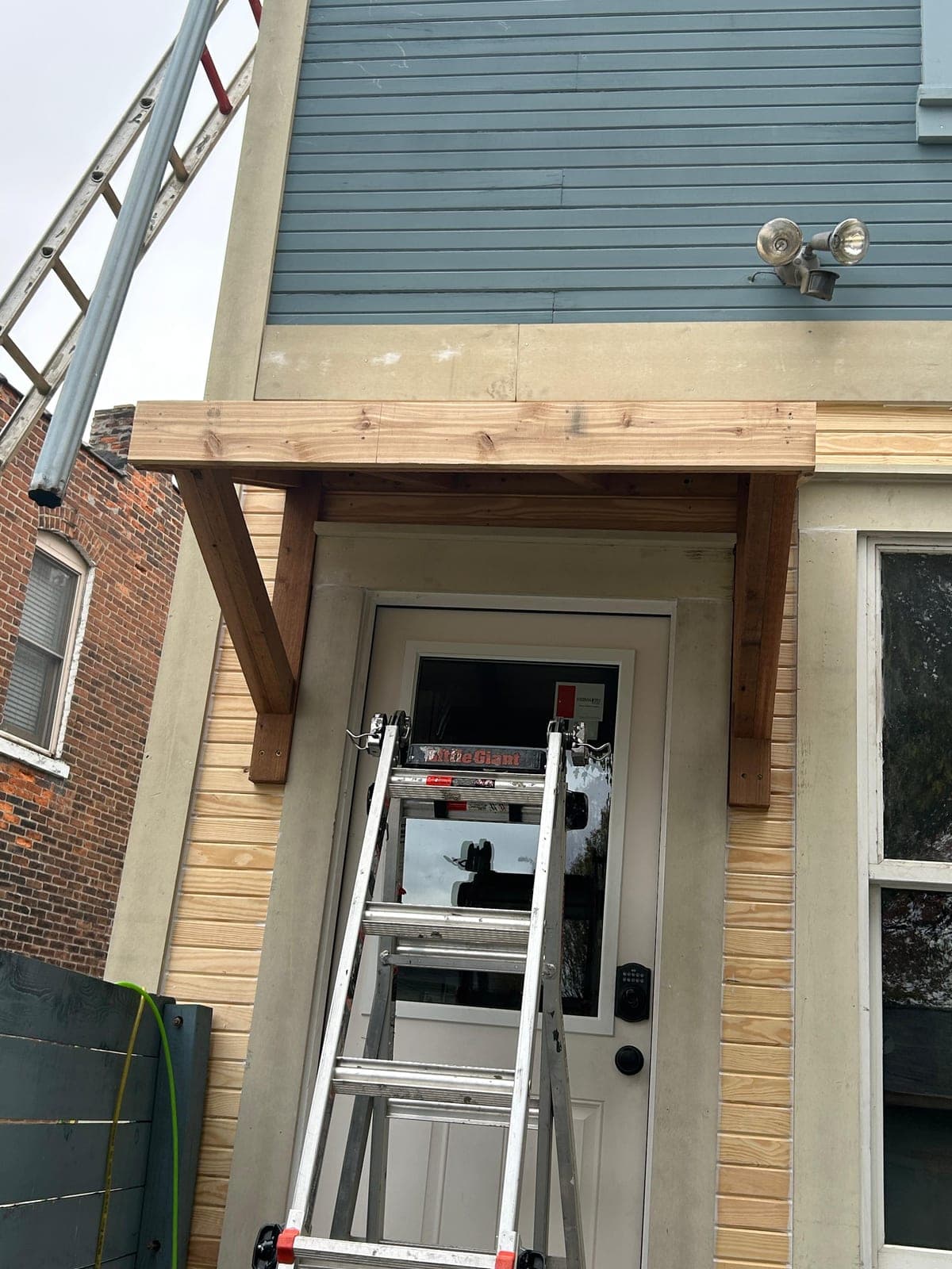 Cedar canopy entry with rebuilt siding